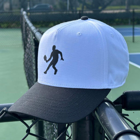 White and black cap with a tennis player silhouette on a tennis court background